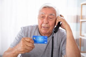 Man With Credit Card Using Landline Phone